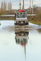 Landrover with kayak driving through water during the February 2014 floods, Gloucestershire, England, UK, 7th February 2014.