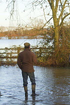 Farm worker in wellington boots and cap stranded by February 2014 floods, Severn  Valley, Gloucestershire, UK, 7th February 2014