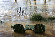 Garden table and chairs with bird feeders all flooded in garden from February 2014 River Severn flood , Upton upon Severn, Worcestershire, England, UK