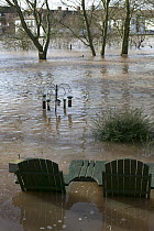 Garden table and chairs with bird feeders in flooded garden from February 2014 River Severn flood , Upton upon Severn, Worcestershire, England, UK