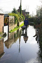 Woman with wheelbarrow of sand bags to prevent flooding to home during February 2014 floods. Upton Upon Severn, Worcestershire, England, UK, 8th February 2014.