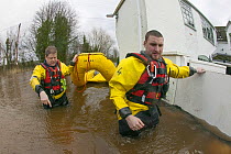 Rescue workers entering property with inflatable raft to check on home owners,  during February 2014 flooding, Upton upon Severn, Worcestershire, England, UK, 9th February 2014.