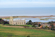 View towards St Nicholas Church, with flooded grazing marsh and breached shingle coastal defense after the 6 December east coast tidal surge in the background, Salthouse, Norfolk, England, UK, Decembe...