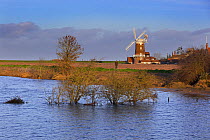 View of flooding after the 6th December east coast tidal surge, with Cley windmill and village in the background, Norfolk, England, UK, December 2013.