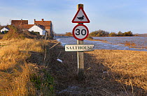 View of signpost and flooding on the coastal road through Salthouse after the 6th December east coast tidal surge, Norfolk, England, UK, December 2013.