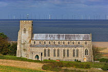 View towards St Nicholas Church, with flooded grazing marsh and breached shingle coastal defense after the 6th December east coast tidal surge in the background, Salthouse, Norfolk, England, UK, Decem...