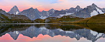 Colourful pink sky at dawn reflected in Fenetre Lake  / Lac de Fenetre in Swiss Alps, 2456 m above sea level. Mont Blanc, Grande Jorasses, Aiguille du Talefre, Aiguille du Triolet and Mont Dolent in F...