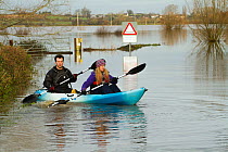 Couple in kayak during January 2014 flooding, North Curry, Somerset Levels, England, UK, 10th January 2014.