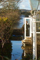 Man standing in doorway of flooded home during January 2014 flooding, Somerset Levels near Langport, Somerset, England, UK, 11th January 2014.
