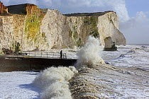 Waves breaking against sea wall and cliffs, Seaford, Sussex, England, UK, 15th February 2014.