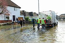 Men handing out sand bags to residents of flooded street, Weybridge, Surrey, England, 10th February 2014.