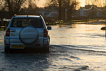 4x4 driving through February 2014 floods from River Thames, Chertsey, Surrey, England, UK, 16th February 2014.