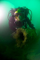 Diver on examining 6'' howitzer on the wreck of the S.S. Serrana. Sunk by UB-35 on the 23 January 1918. Eastern Solent, England, August 2013.