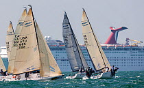 Sail boats race past a cruise ship during 2013 Key West Race Week, Florida. All non-editorial uses must be cleared individually.