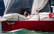 Crew member taking spinnaker down during Key West Race Week 2013, Florida. All non-editorial uses must be cleared individually.