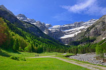 Two people walking along track leading to the Cirque de Gavarnie, Pyrenees National Park, France, June 2013.