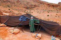 Bedouin nomad standing outside tent, Sahara Desert, Morocco, North Africa, March 2011.