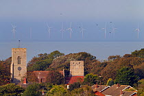 Church with North Sea wind farm in the distance, Weybourne, Norfolk, UK, October 2013.