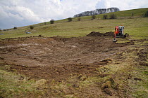 Medieval Dewpond being renovated as part of the Marlborough Downs Nature Improvement Area project, Barbury Castle, Wiltshire, UK, March 2013.