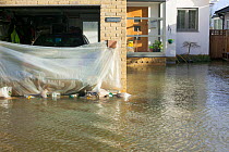 Car protected from flood water by makeshift plastic sheet in garage. February 2014 floods from the River Thames, Sunbury on Thames, Surrey, England, UK, 15th February 2014.