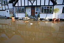 Home flooded during February 2014 floods with sandbags outside. Surrey, England, UK, 16th February 2014.