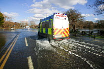 Police van driving through February 2014 floods. Chertsey, Surrey, England, UK, 16th February 2014.