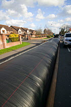 Flood protection barrier (filled with water) to protect homes during February 2014 flooding. Chertsey, Surrey, England, UK, 16th February 2014.