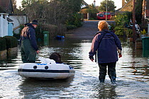 Residents transporting their dog on a rib during February 2014 floods, Sunbury on Thames, Surrey, England, UK, 15th February 2014.