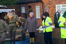 Army, residents and Environment Agency staff in flooded street after February 2014 flooding, helping to provide support for the residents, Chertsey, Surrey, England, UK, 16th February 2014.