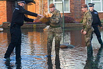 Army and police in flooded street after February 2014 flooding, helping to provide support for the residents and supplying sand bags, Chertsey, Surrey, England, UK, 16th February 2014.