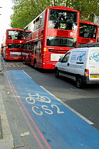 CS2 Barclay&#39;s Cycle Superhighway Route Two with red London double-decker buses close alongside, Bow Road, London Borough of Tower Hamlets, England, UK, October 2013.
