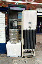 Fly tipping - old household appliances and other scrap metal suitable for recycling blocking the entrance to a public telephone box outside Drayton Park Station, Highbury, London Borough of Islington,...