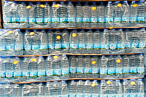 Packs of mineral drinking water in plastic bottles for sale outside local shop in Holloway, London Borough of Islington, England UK, March 2013.