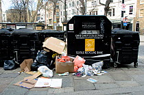 Textile recycling bank with rubbish in front, Islington Green, London, England, UK, March 2013.
