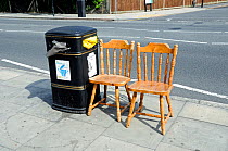 Two wooden chairs put into street for recycling, Highbury, London Borough of Islington, England, UK, June 2013.