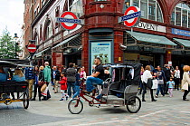 Urban Rickshaw with driver or rider outside Covent Garden Underground Station, an sustainable form of transport, Central London, England, UK, June 2013.