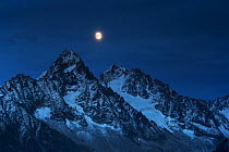 Aiguilles at night with full moon over the mountain landscape, Chamonix, Haute Savoie, France, September 2012.