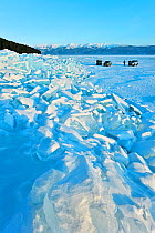 Landscape of Lake Baikal frozen in spring, with ice pile and cars, Lake Baikal, Siberia, Russia, March 2013.