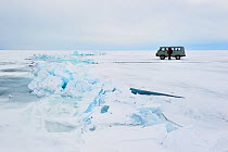 Mini van crossing Lake Baikal ice, Siberia, Russia, March.