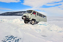 Mini van crossing over pile of ice on Lake Baikal,  Siberia, Russia, March.