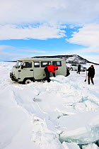 Mini van and people on Lake Baikal ice, Siberia, Russia, March.