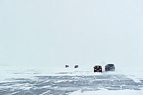 Cars driving across Lake Baikal ice in spring, Siberia, Russia, March.