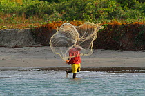 Man throwing out fishing net, Gambia, West Africa, November 2012.