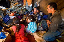 A Chukchi family watching a movie on a notebook computer inside a Yaranga (traditional tent) at a reindeer herder's camp. Iultinsky District, Chukotka, Siberia, Russia, August 2013.