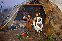 Yarosalva and Nadia, two Chukchi girls, stand by a ritual fire at the entrance of a Yaranga (tent) and watch the start of the Chukchi 'Festival of the Young Reindeer' at a herders' summer camp. Iultin...
