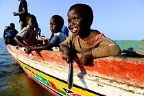 Children playing with fishes on a fishing boat, Eticoga, Orango Island, Guinea-Bissau, December 2013.