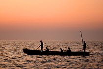 Fishermen in boat at sunset, Orango Island, Guinea-Bissau. December 2013.