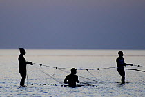 Fishermen with net at low tide, Orango Island, Guinea-Bissau, December 2013.