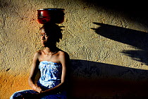 Nalu girl, portrait with metal bowl on head, Cabedu village. Cantanahez National Park, Guinea-Bissau, December 2013.