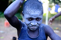 Nalu boy covering himself with blue powder whilst preparing for a ritual dance, Cabedu village, Guinea-Bissau, December 2013.